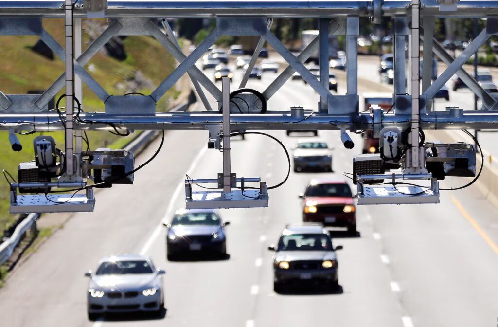 Highway electronic toll gantry with license plate cameras capturing vehicles for automatic toll collection