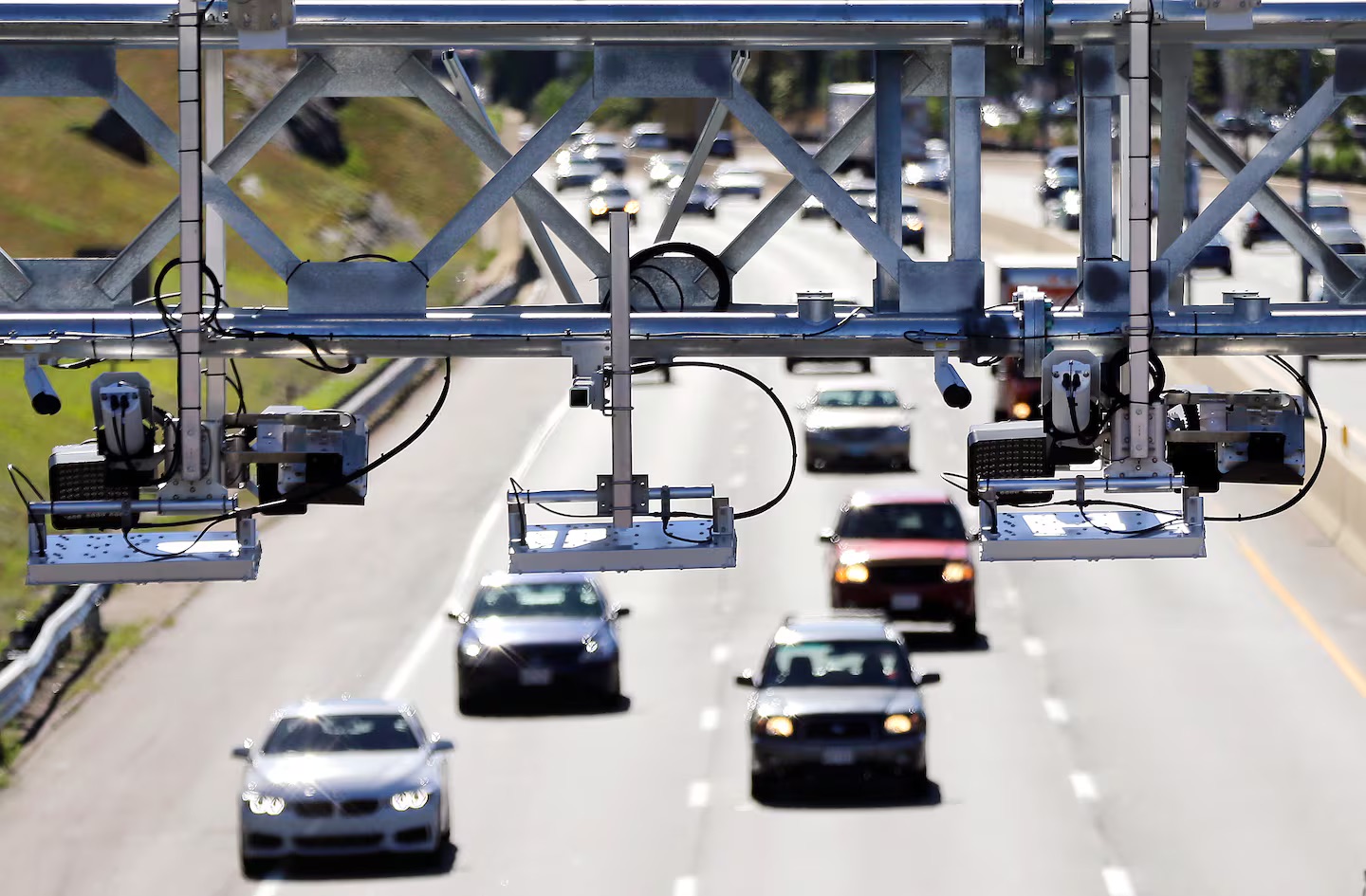 Highway electronic toll gantry with license plate cameras capturing vehicles for automatic toll collection